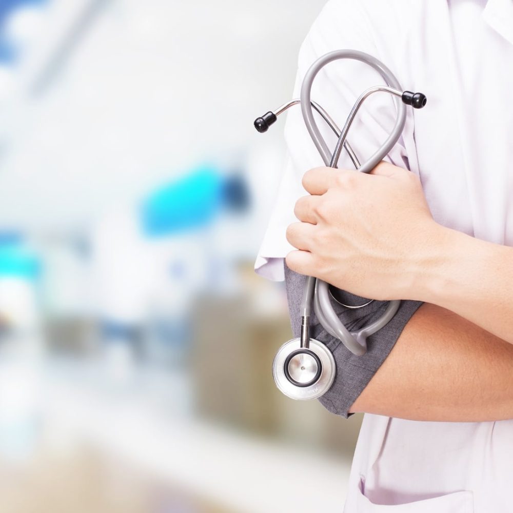 Doctor with a stethoscope in the hands and hospital background